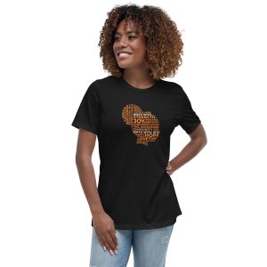 A smiling woman with curly hair wears a black t-shirt featuring an artistic design of a map shape filled with words.